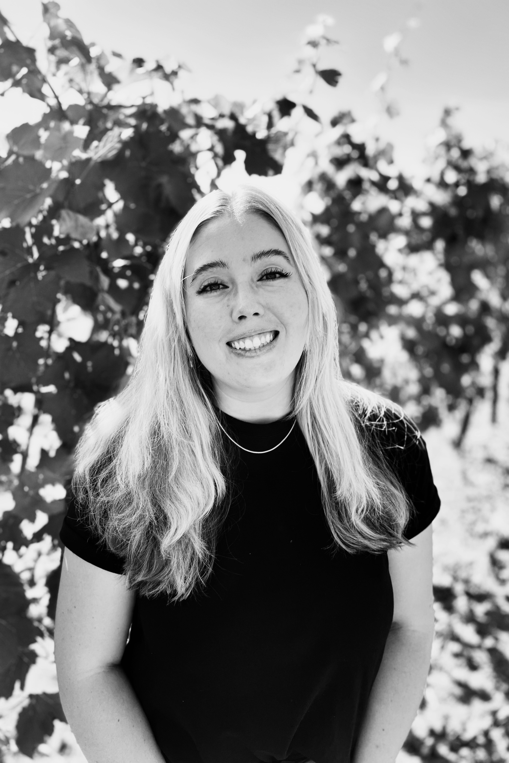 Kayla B&W 1500×1000 Image of Kayla Savage - Hospitality Associate - out in the vineyard.